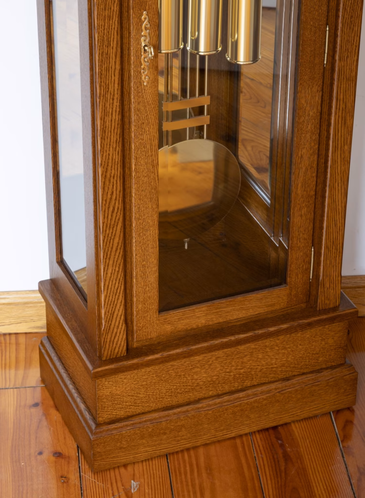 Lower case of grandfather clock with beveled glass and polished brass pendulum